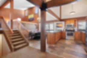 Inside a Gold Point condo, with an open staircase, a timber post, and a full kitchen